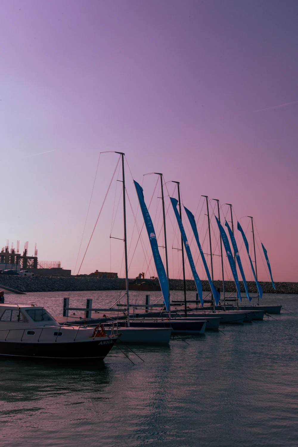 Masts and flags by the pontoon at sunset